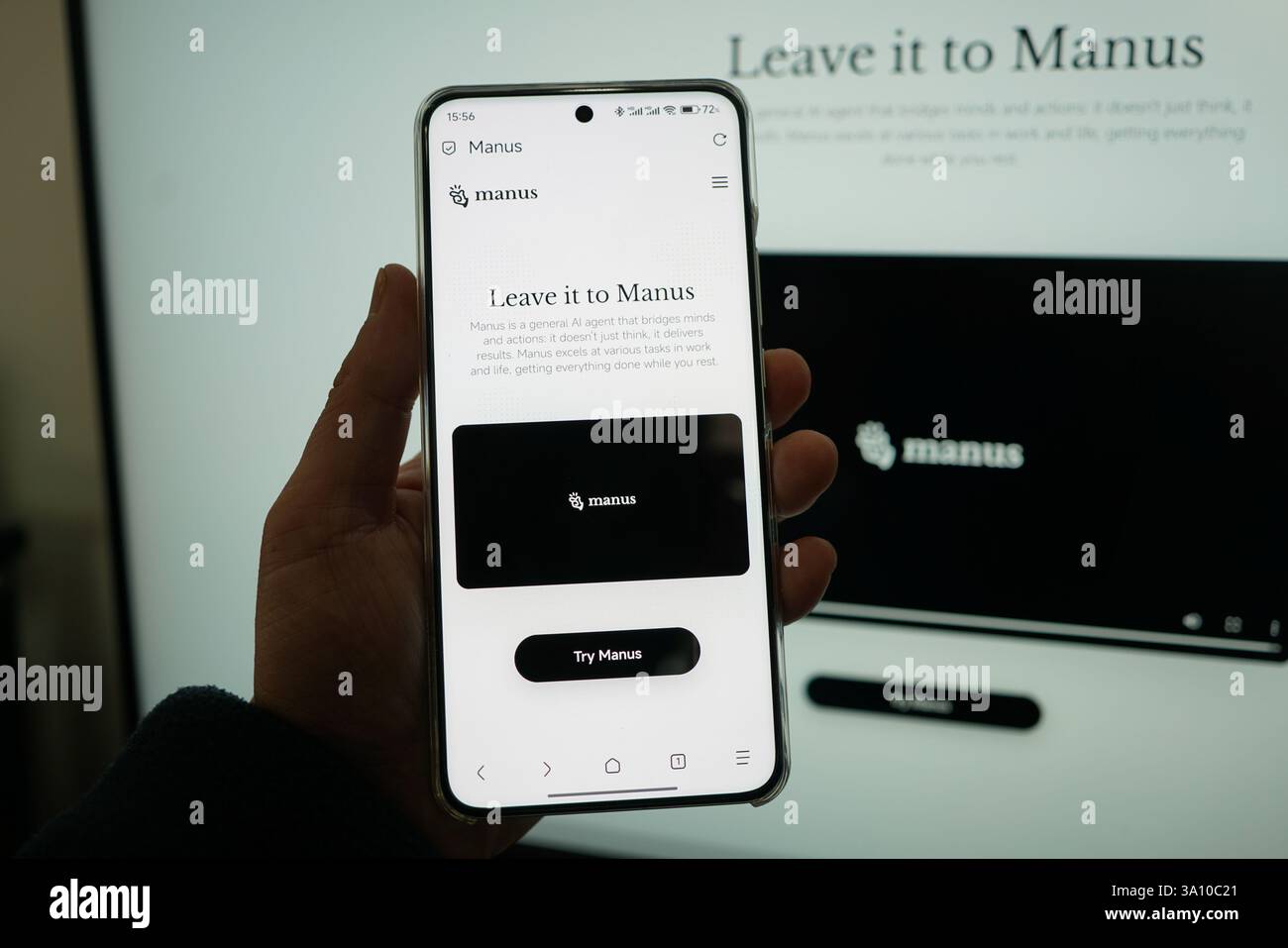 Un giovane usa il suo telefono cellulare e il suo computer per controllare l'introduzione della home page dell'agente intelligente ai Manus a Shanghai, Cina, marzo Foto Stock