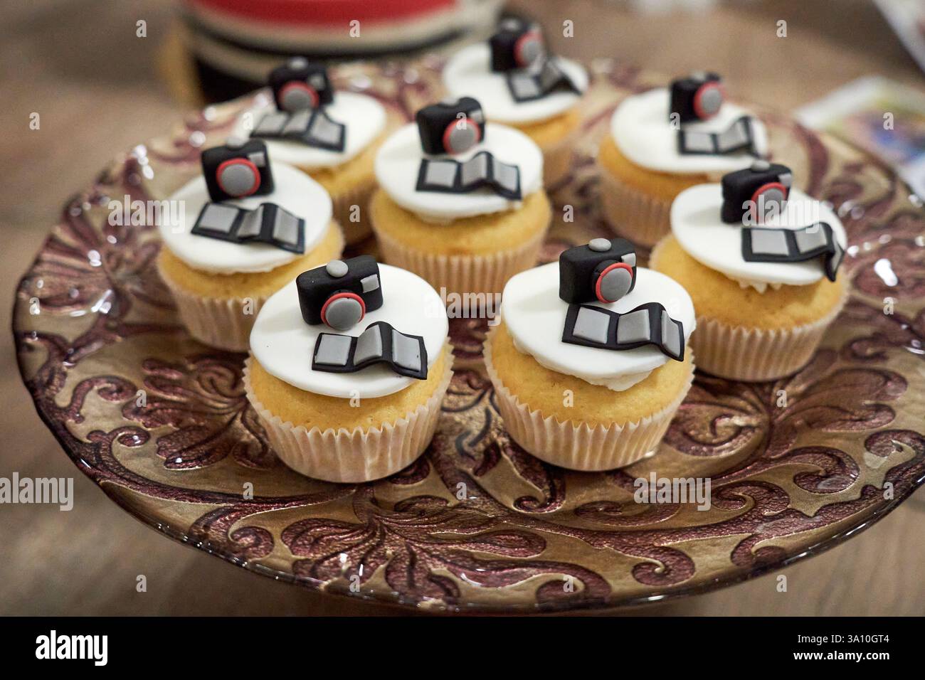 Selezione di cupcake alla vaniglia fatti in casa decorati con macchine fotografiche e strisce cinematografiche originali in miniatura commestibili a Cosenza, Calabria, Italia. Foto Stock