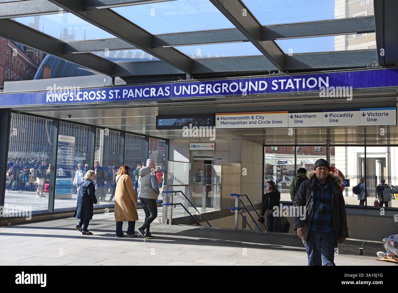 Ingresso, King's Cross e stazione della metropolitana di St Pancras, Camden, Londra, Regno Unito - persone che entrano nella metropolitana. Foto Stock