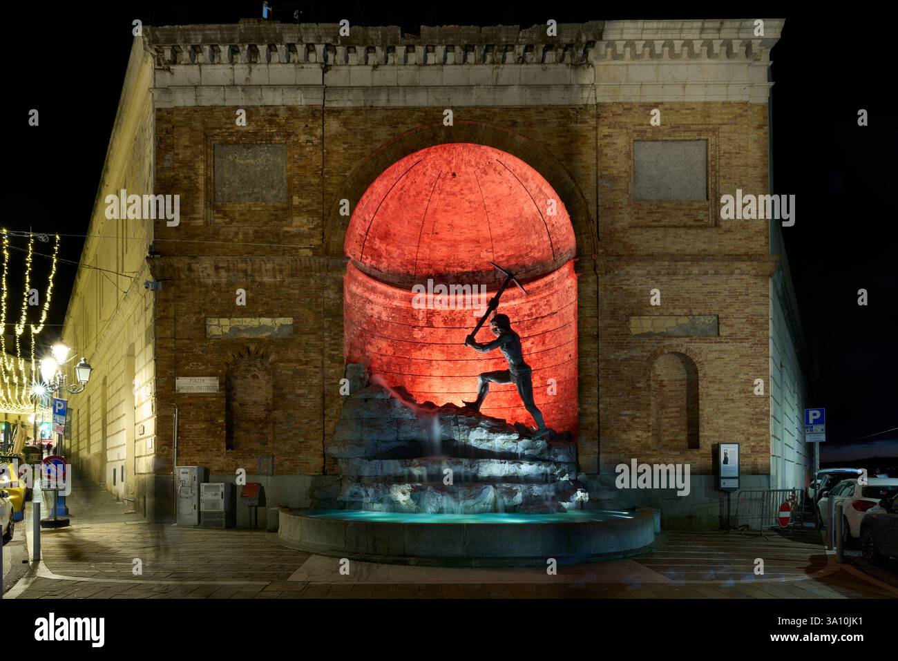 Veduta notturna del monumento "il Cavatore" dello scultore Giuseppe Rito, illuminato da luce rossa e collocato in una nicchia del complesso di San Giovanni Foto Stock