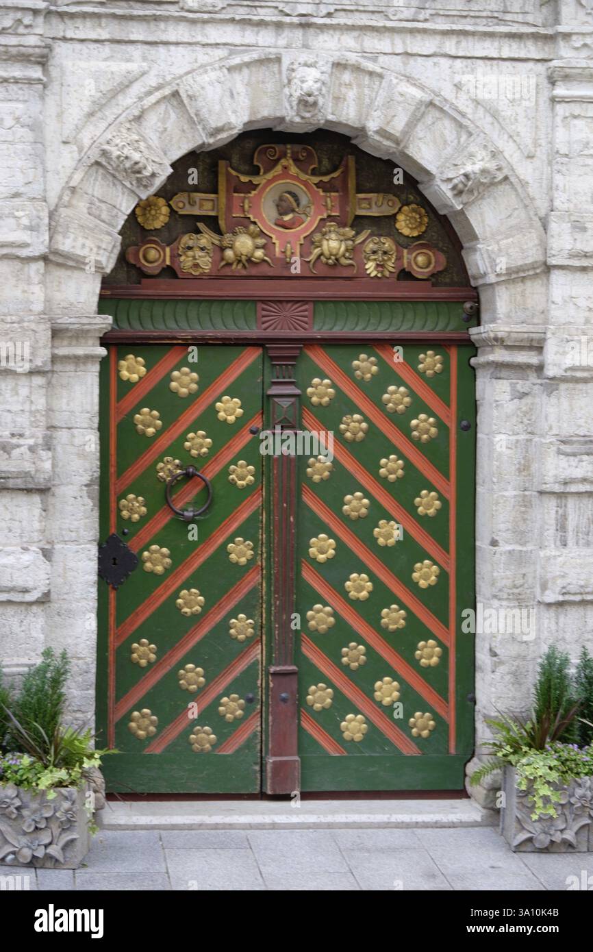 Porta ornata in legno con arco in pietra, piante decorative su entrambi i lati, Tallinn, Estonia, Europa Foto Stock