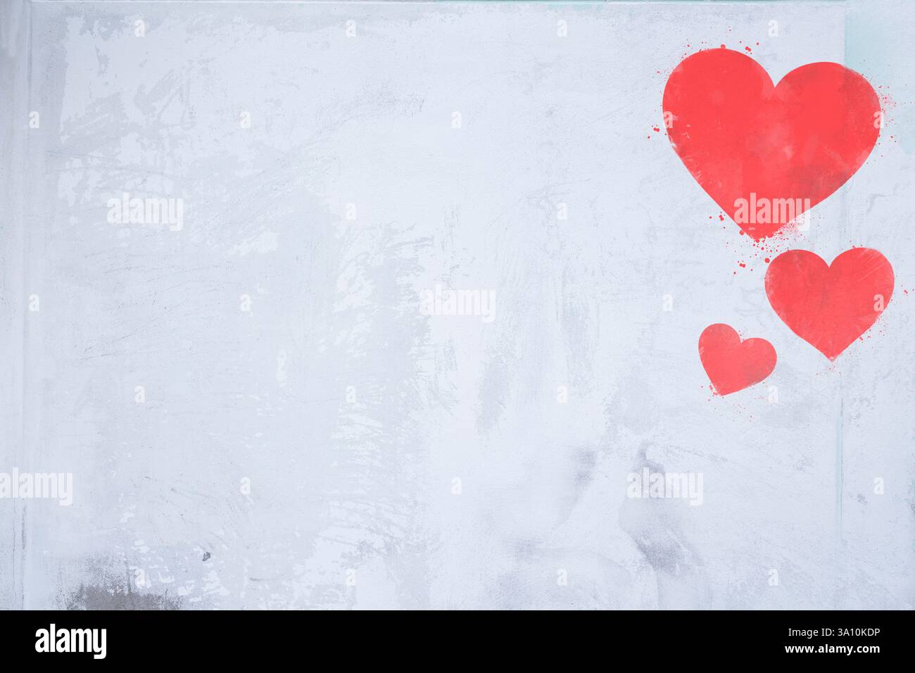 Vista frontale di una parete in grigio chiaro con tre cuori dipinti di rosso. Simbolo dell'amore e San Valentino. Sfondo per eventi e celebrazioni romantiche Foto Stock