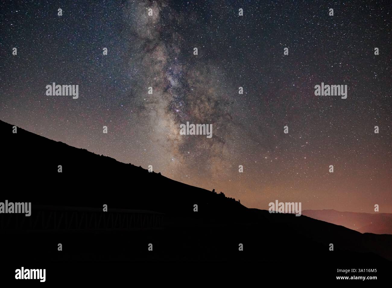 Silhouette delle colline con la via Lattea sullo sfondo. Fotografia di concetto di astrofotografia. Effetto rumore incluso. Foto Stock