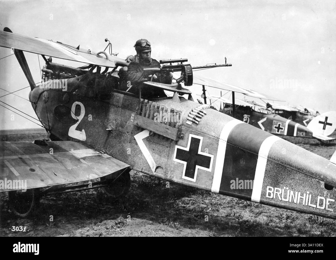 L'obbeserver di questo Halberstadt CL. II controlla la sua mitragliatrice 7,92 mm Parabellum MG14 prima di un'altra sortita. Progettato per il supporto aria-terra, l'aereo è dotato di rack contenenti dieci granate a bastone. Foto Stock