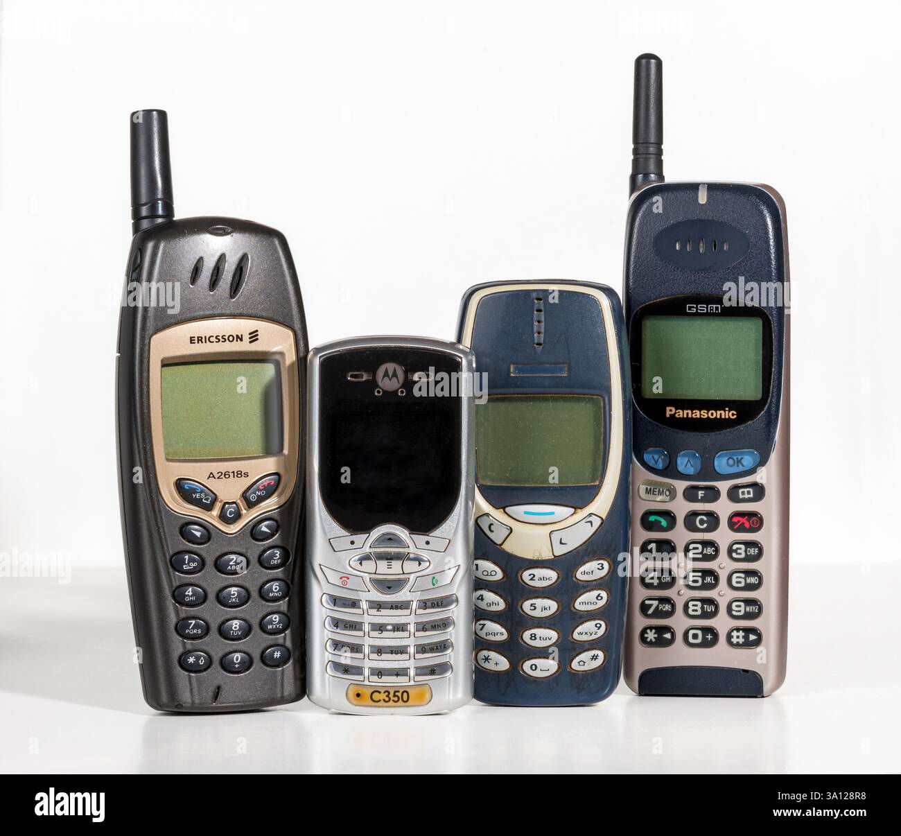Quattro telefoni cellulari retrò di marchi famosi posizionati in verticale su uno sfondo bianco, che mostrano la tecnologia di comunicazione degli anni '2000 Foto Stock