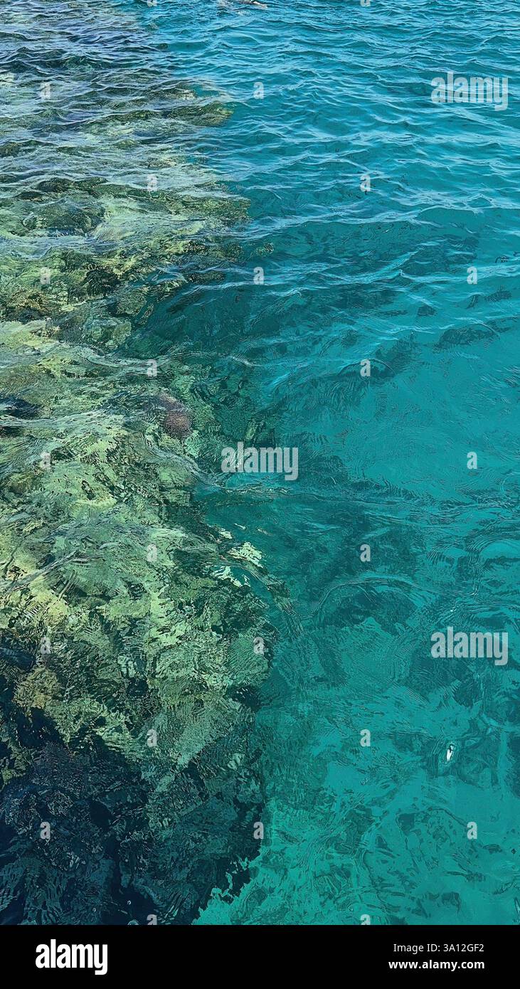 Sfondo, vista dall'alto del Mar Rosso con onde luminose e una barriera corallina Foto Stock
