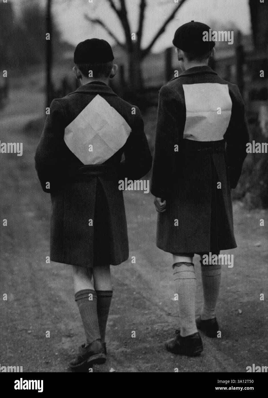 Per sicurezza - questi sfollati indossano un white paper fissato sulla schiena quando camminano lungo il paese leggono dopo un periodo di balck-out in una città del Berkshire. 7 febbraio 1941. (Foto di Fox Photos). Foto Stock