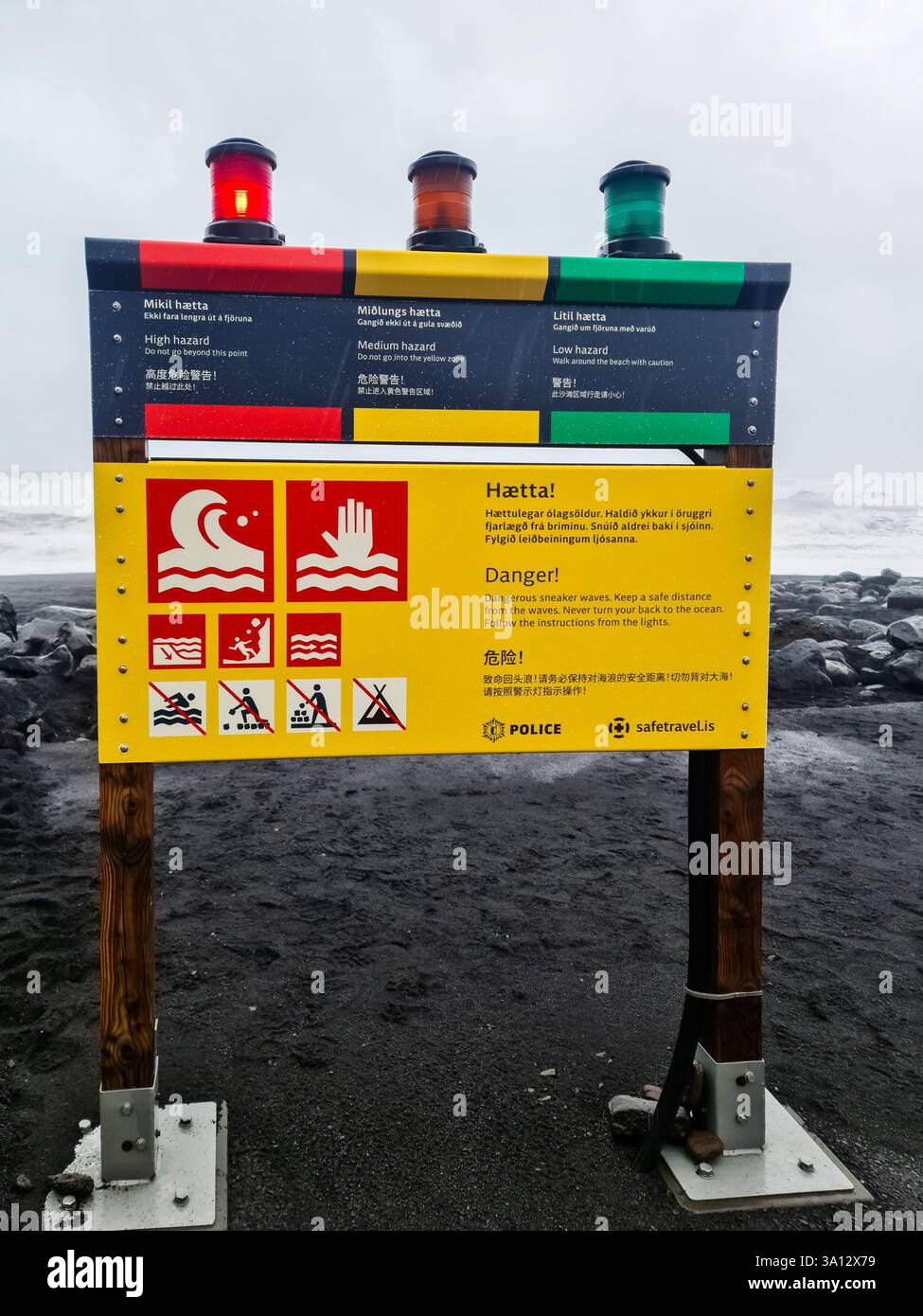 Islanda, Islanda - 01. Marzo 2025: Cartello di avvertimento multilingue con semaforo che mostra i livelli di pericolo delle onde delle sneaker sulla spiaggia di Reynisfjara in Islanda Foto Stock