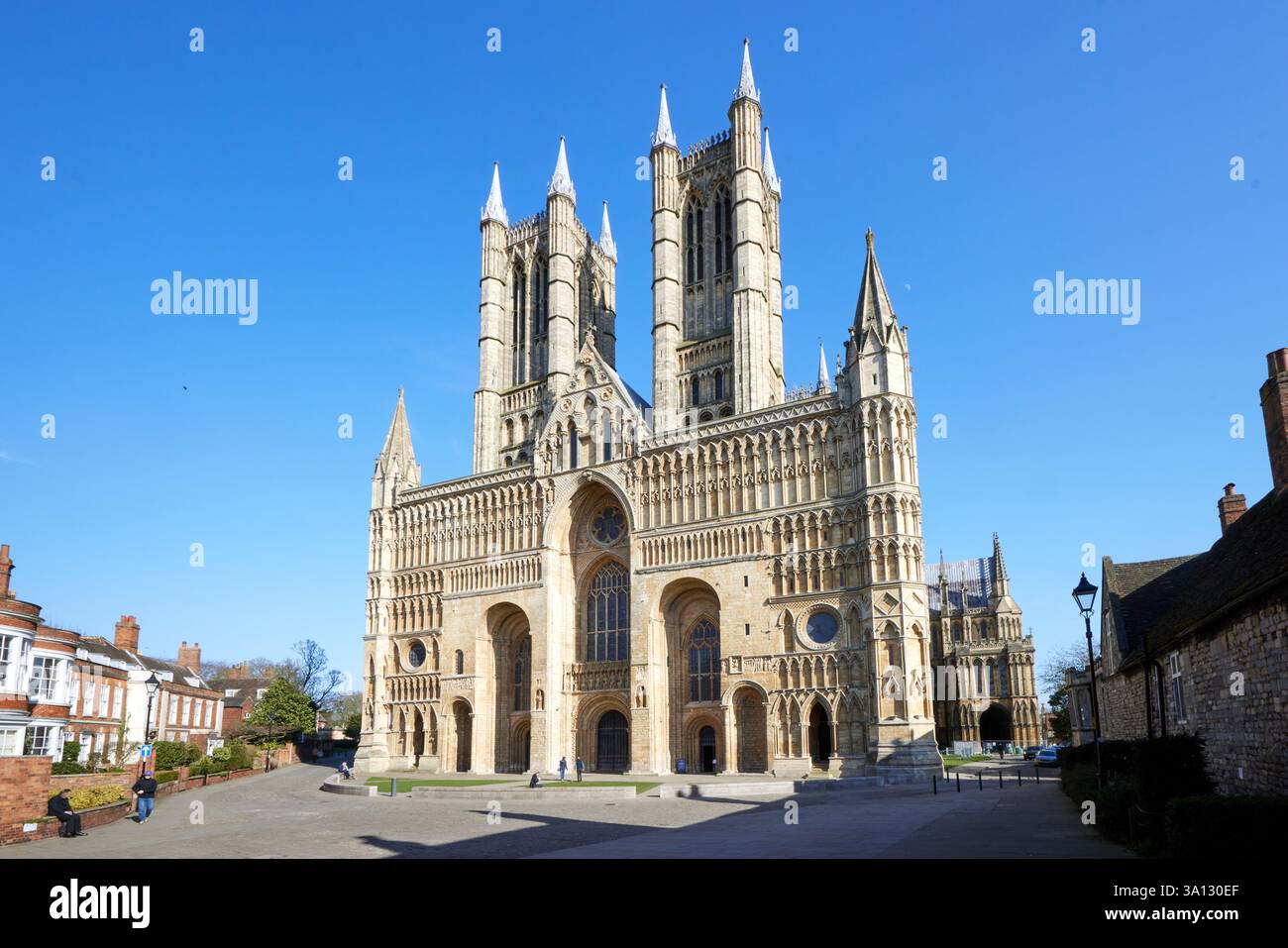 Il fronte occidentale della cattedrale di Lincoln è una grandiosa facciata medievale caratterizzata da un'intricata architettura gotica, guglie torreggianti e grandi porte ad arco. Foto Stock