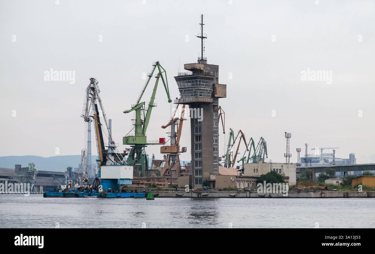 Porto marittimo con grandi gru e strutture industriali, compresa una torre di osservazione per le operazioni Foto Stock