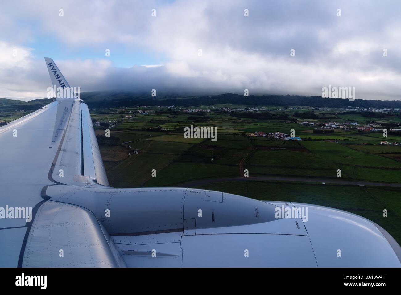 Angra do Heroismo, Portogallo - 30 giugno 2022: Un Airbus A320 Lauda Air è parcheggiato sull'asfalto in una giornata limpida, con vari veicoli e autobus aeroportuali Foto Stock
