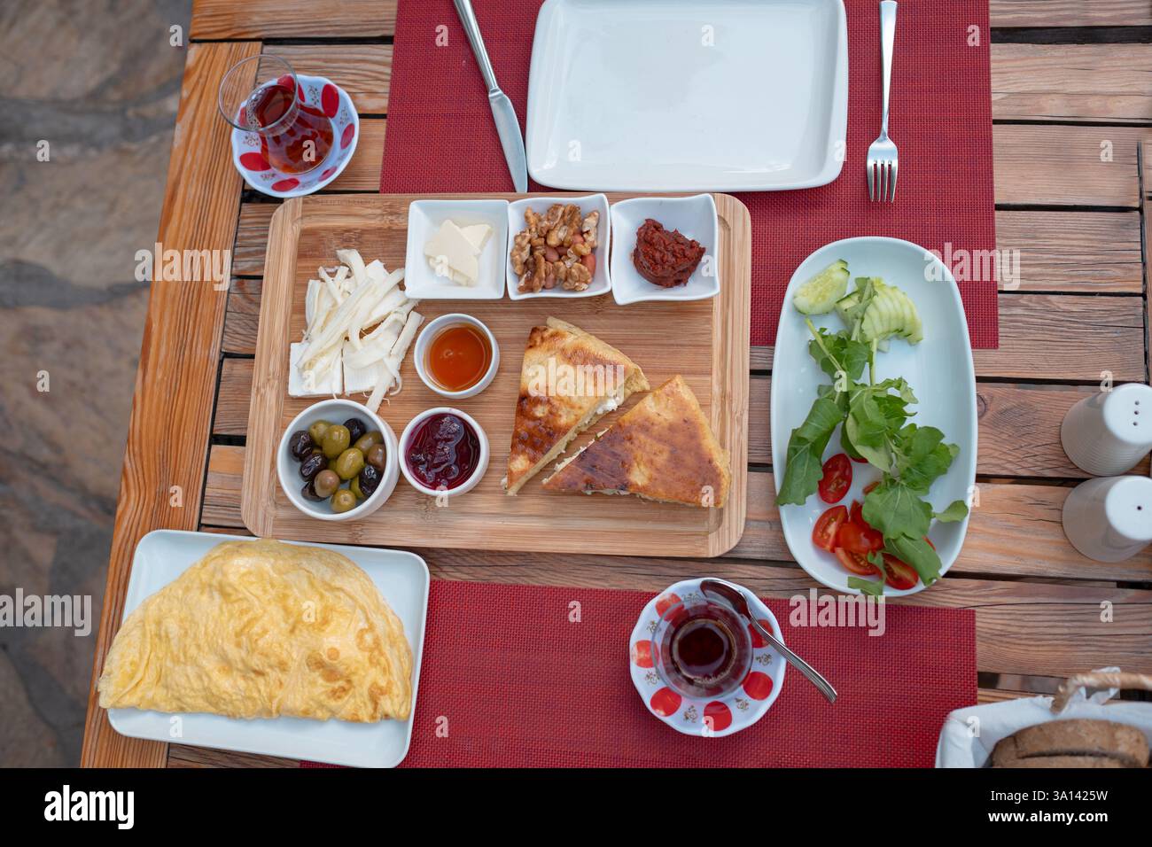 Colazione tradizionale turca con pane fresco, olive, formaggio, pomodori, cetrioli, e varietà di inceppamenti e spalmazioni. Godibile in un ambiente vivace Foto Stock