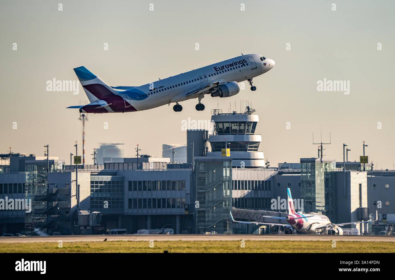 Aeromobili Eurowings Airbus A320 in decollo sulla pista principale sud, 05R/23L, aeroporto internazionale di Düsseldorf, edificio del terminal, vecchio traffico aereo continua Foto Stock