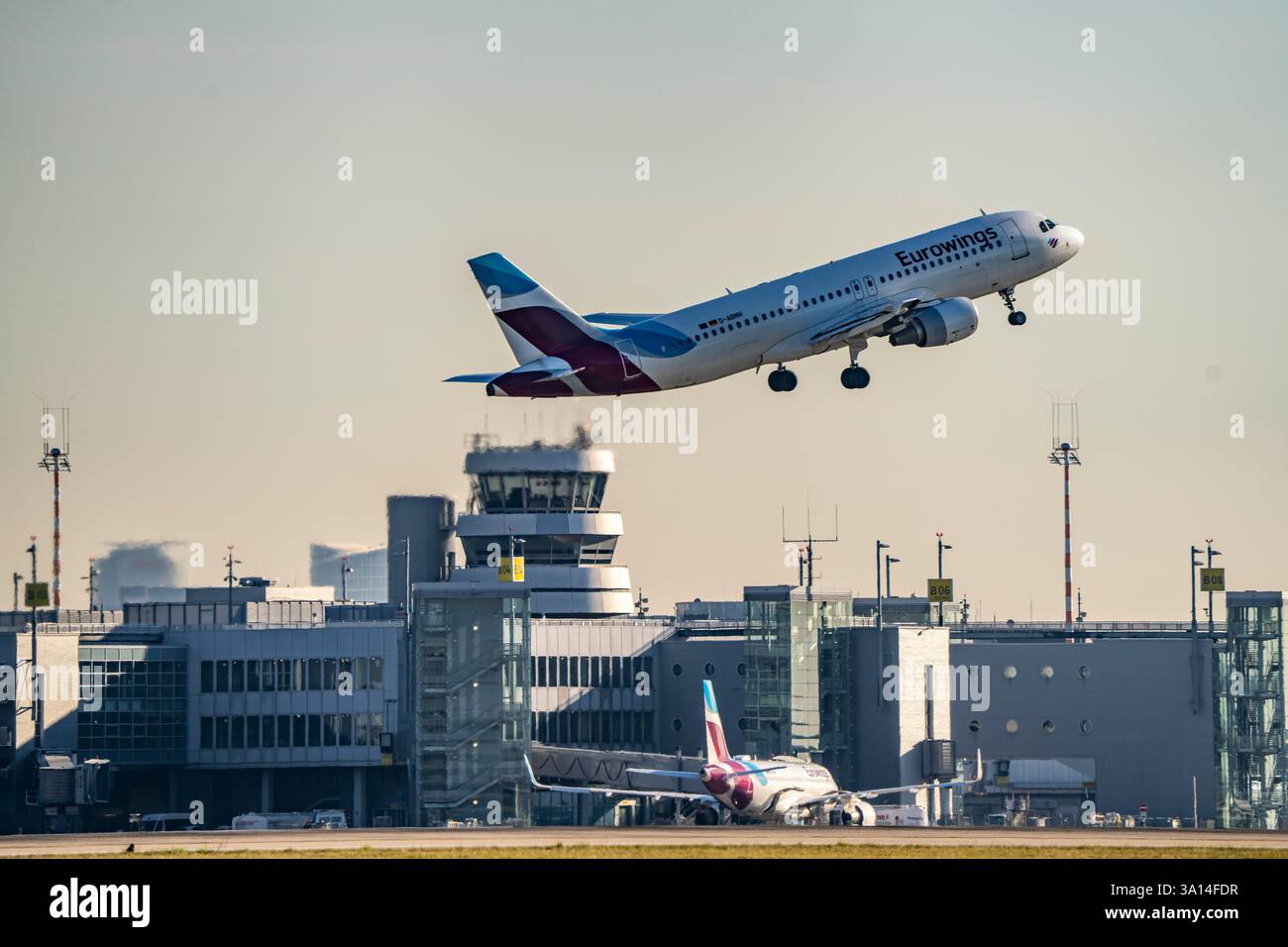 Aeromobili Eurowings Airbus A320 in decollo sulla pista principale sud, 05R/23L, aeroporto internazionale di Düsseldorf, edificio del terminal, vecchio traffico aereo continua Foto Stock