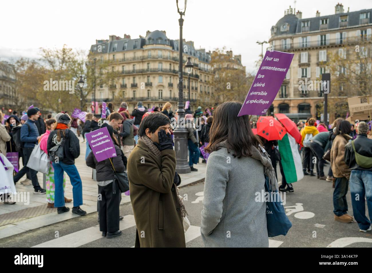 I manifestanti si riuniscono in una piazza storica, sostenendo i diritti delle donne e l'uguaglianza durante una vivace manifestazione a Parigi Foto Stock