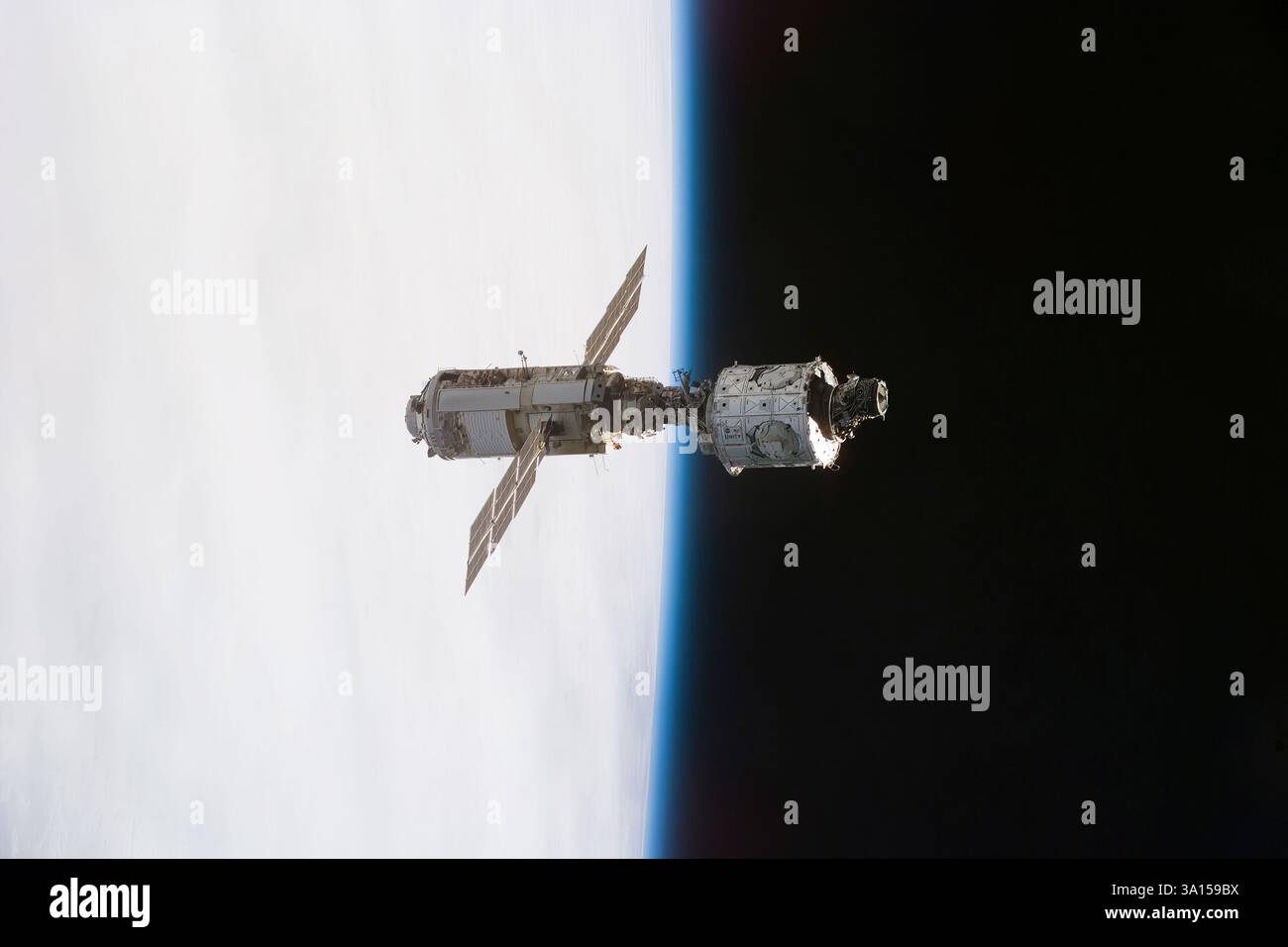 I moduli Zarya e Unity costruiti in Russia, recentemente accoppiati, fluttuano contro l'orizzonte terrestre dopo lo schieramento dallo Space Shuttle Endeavour durante Foto Stock