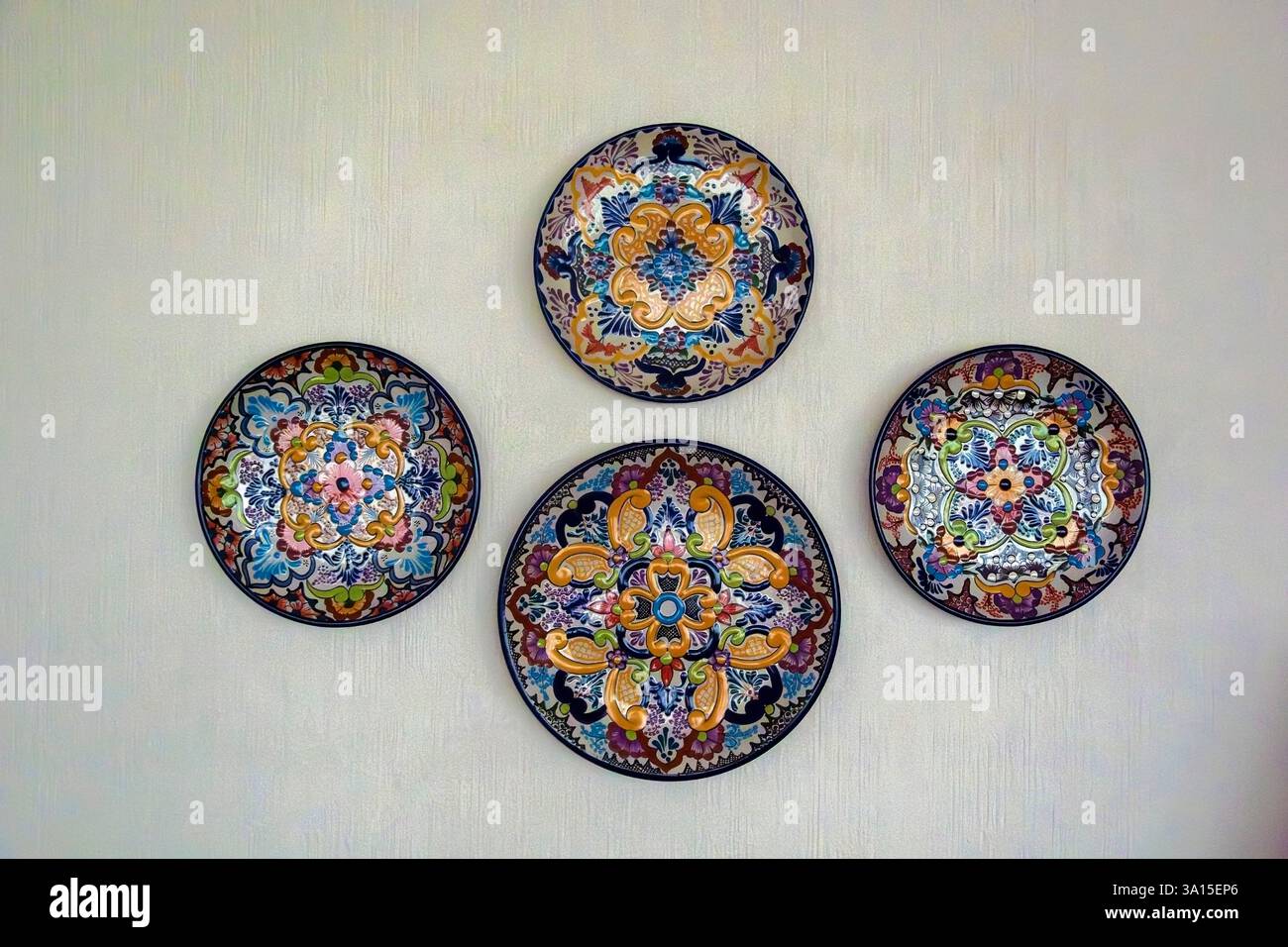 Piastre ornamentali in ceramica messicana isolate su una parete bianca Foto Stock