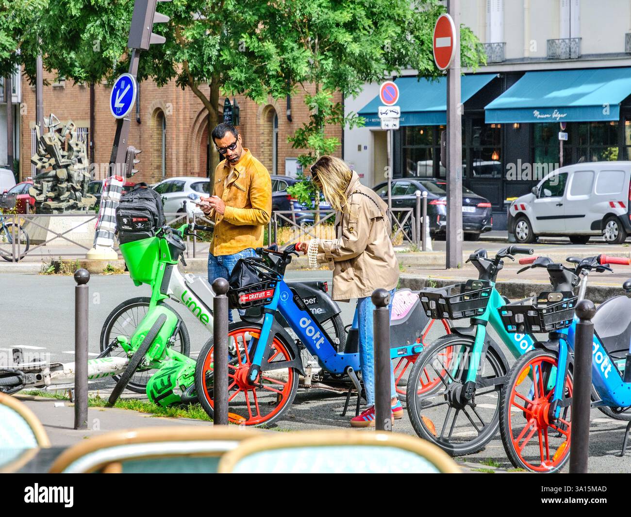 Due amici che scelgono le biciclette elettriche Lime e Dott - Montparnasse-Raspail, Parigi 75014, Francia. Foto Stock