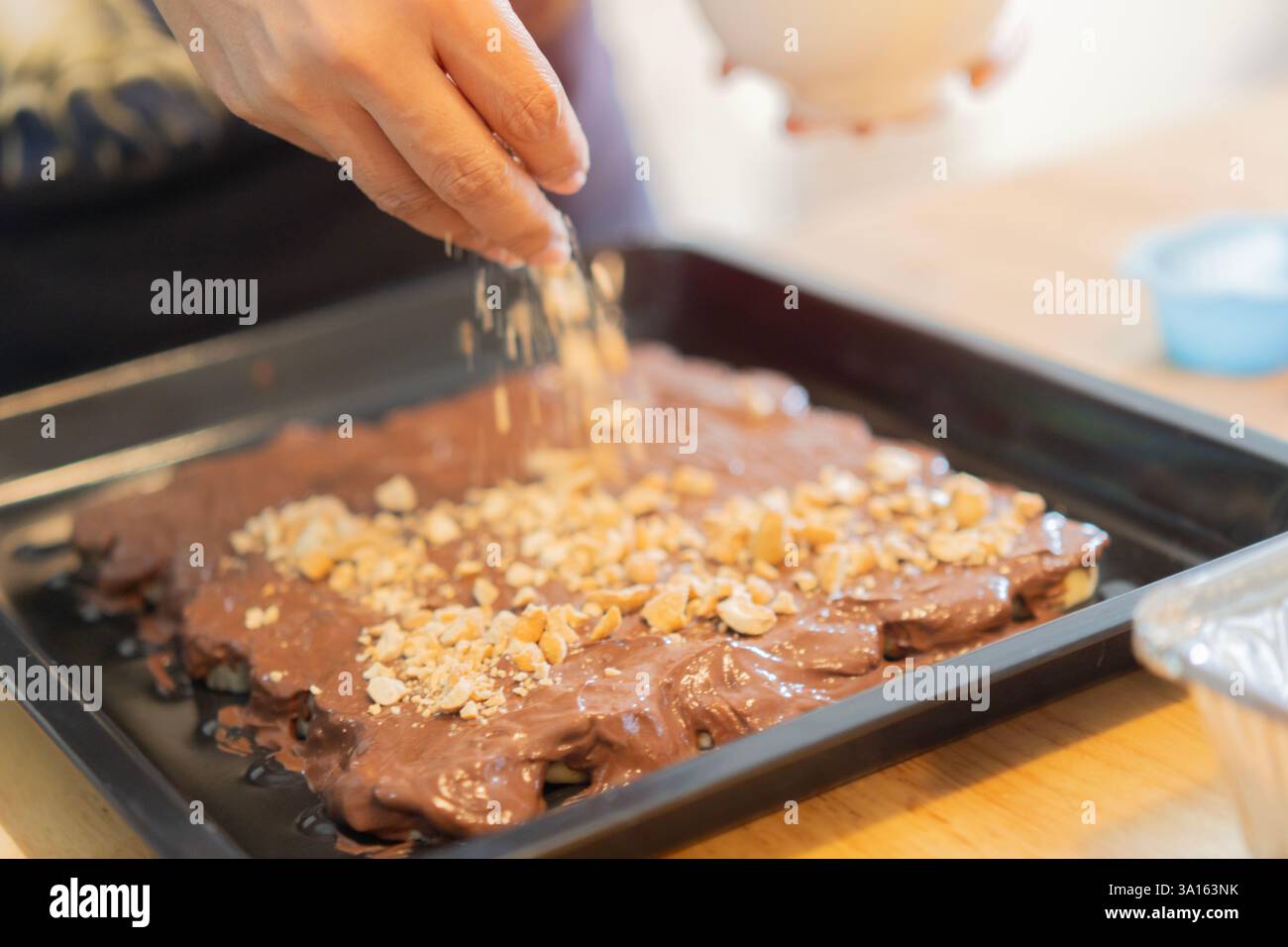 Chef, cottura e torta alla banana con penut e cioccolato in una cucina da donna che prepara un dolce dessert o un compleanno. Messa a fuoco selettiva. Foto Stock