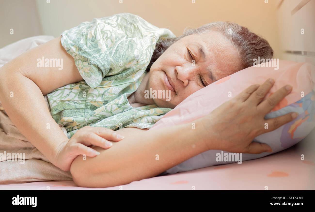 Donna anziana preoccupata che soffre di insonnia. Una vecchia sdraiata a letto con gli occhi aperti. Donna matura incapace di dormire a casa. Foto Stock