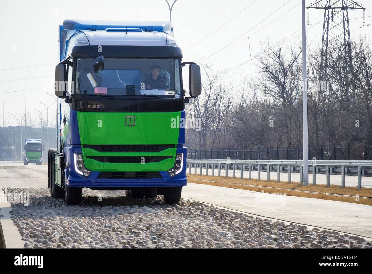 Tianjin, Cina. 5 marzo 2025. Un membro dello staff guida dei pesanti tucks di pile a combustibile a idrogeno per una prova su strada il 5 marzo 2025 a Tianjin, in Cina. Il 5 marzo a Tianjin è uscito dalla linea di produzione un lotto di tubi pesanti alimentati da celle a combustibile a idrogeno da 200 kilowatt. I dumper pesanti hanno una portata massima di oltre 700 chilometri, adatti per la logistica su media e lunga distanza. Credito: Tong Yu/China News Service/Alamy Live News Foto Stock