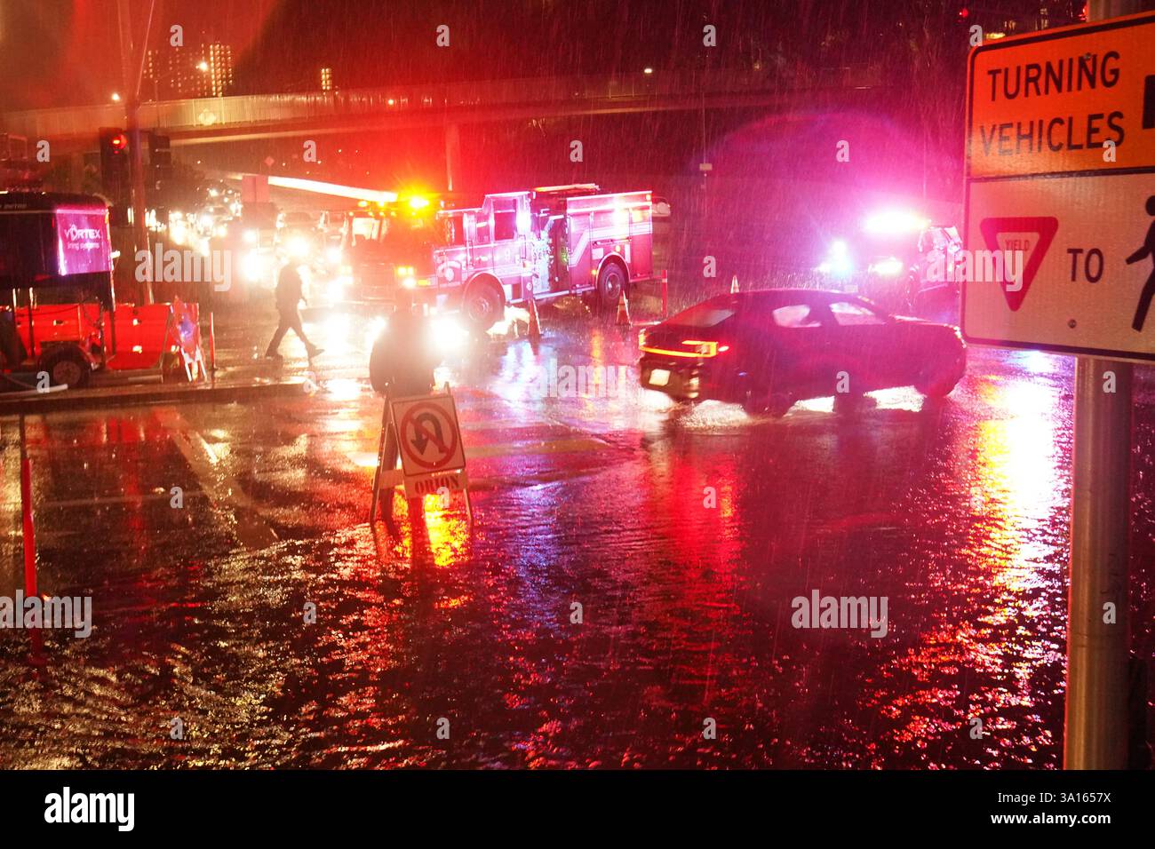 La polizia coordina il traffico in un tratto allagato della strada. San Diego ha subito una forte pioggia che ha portato a significative inondazioni in tutta la città. Nell'area di la Jolla, almeno quattro auto sono sommerse con livelli d'acqua quasi interamente coperti. Contemporaneamente, diversi incidenti automobilistici si sono verificati durante la tempesta, provocando risposte dal dipartimento di polizia di San Diego. Le autorità hanno chiuso le strade allagate per garantire la sicurezza pubblica, mentre il National Weather Service ha emesso un avviso di inondazione per alcune zone di San Diego. Foto Stock