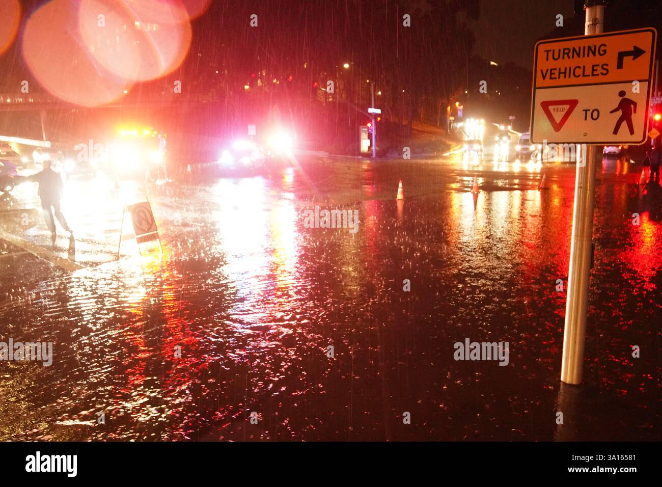 La polizia coordina il traffico in un tratto allagato della strada. San Diego ha subito una forte pioggia che ha portato a significative inondazioni in tutta la città. Nell'area di la Jolla, almeno quattro auto sono sommerse con livelli d'acqua quasi interamente coperti. Contemporaneamente, diversi incidenti automobilistici si sono verificati durante la tempesta, provocando risposte dal dipartimento di polizia di San Diego. Le autorità hanno chiuso le strade allagate per garantire la sicurezza pubblica, mentre il National Weather Service ha emesso un avviso di inondazione per alcune zone di San Diego. Foto Stock