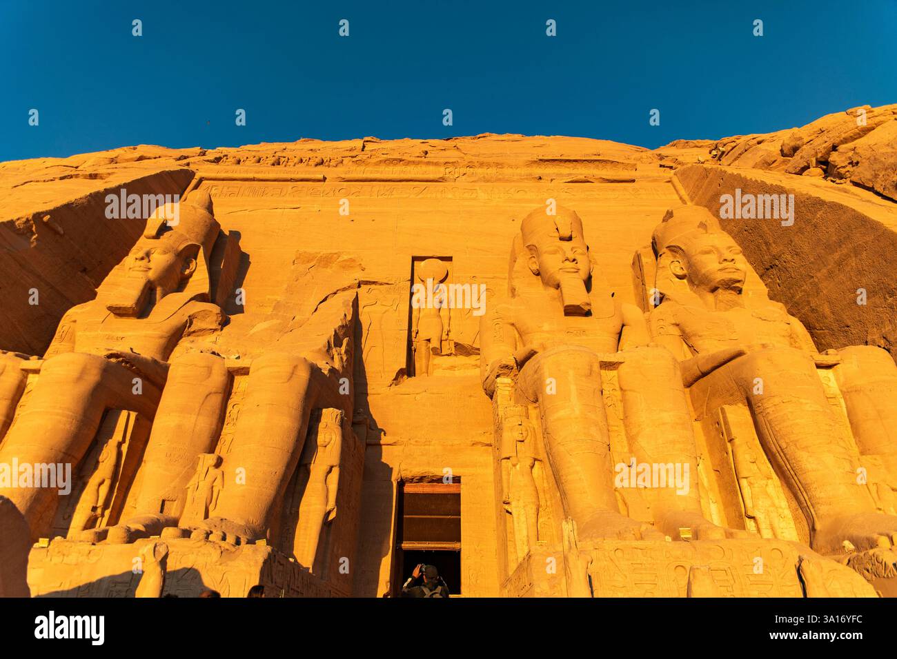 Ammira la maestosa facciata del famoso Tempio di Ramses ad Abu Simbel, vicino al Nilo, nella terra faraonica. Scopri la sua brillantezza architettonica Foto Stock