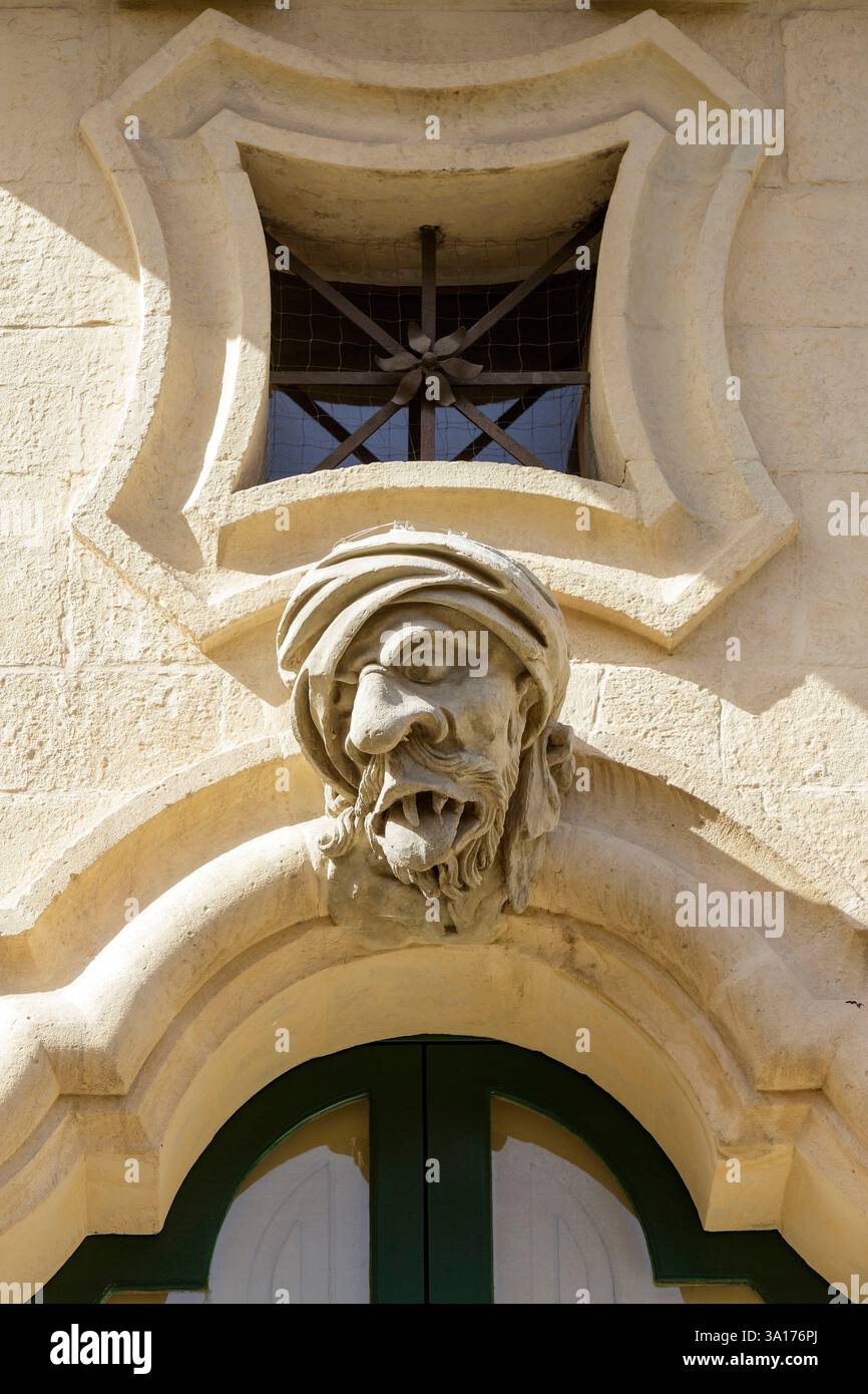 Italia, Sicilia, Ragusa, città dichiarata Patrimonio dell'Umanità dall'UNESCO, dettaglio della facciata del Palazzo Bertini costruito in stile barocco nel XVIII secolo a Ragusa superiore (alta Ragusa) situato in corso Italia, uno dei tre volti ridicoli della facciata tipica dello stile barocco che rappresenta il mendicante Foto Stock