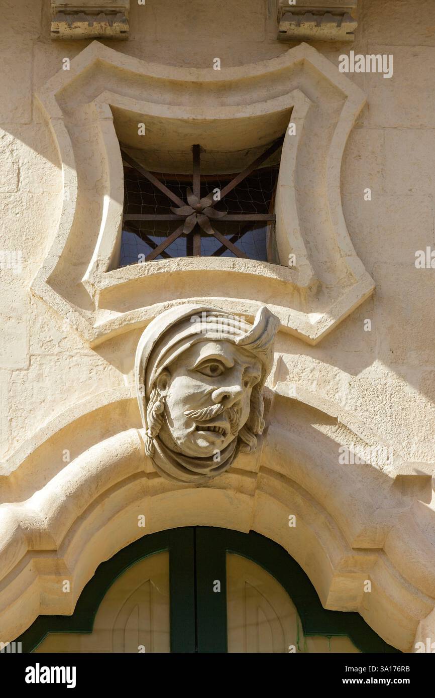 Italia, Sicilia, Ragusa, città dichiarata Patrimonio dell'Umanità dall'UNESCO, dettaglio della facciata del Palazzo Bertini costruito in stile barocco nel XVIII secolo a Ragusa superiore (alta Ragusa) situato in corso Italia, uno dei tre volti ridicoli della facciata tipica dello stile barocco che rappresenta l'uomo dell'Oriente Foto Stock