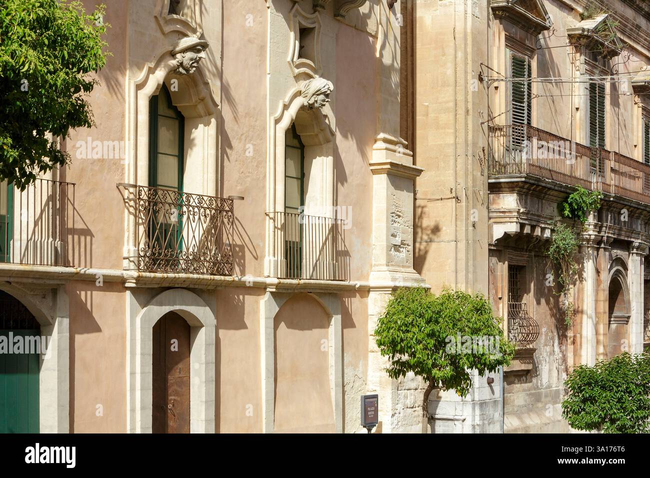 Italia, Sicilia, Ragusa, città dichiarata Patrimonio Mondiale dell'Umanità dall'UNESCO, facciata del Palazzo Bertini costruito in stile barocco nel XVIII secolo a Ragusa superiore (alta Ragusa) situato in corso Italia, i volti ridicoli della facciata sono tipici dello stile barocco e rappresentano da sinistra a destra il nobile e l'uomo dell'est Foto Stock
