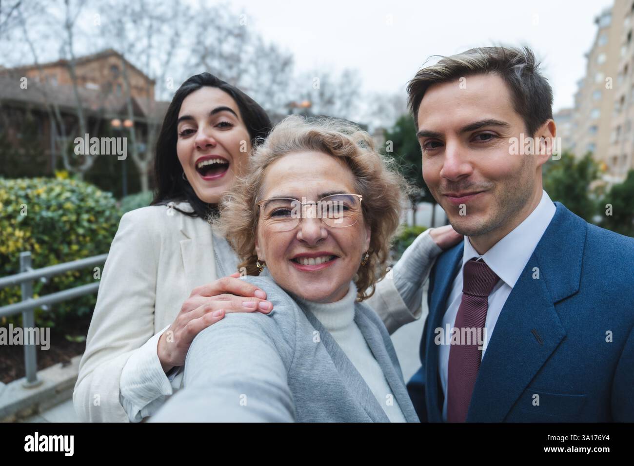 Famiglia felice che scatta un selfie all'aperto in un ambiente urbano Foto Stock
