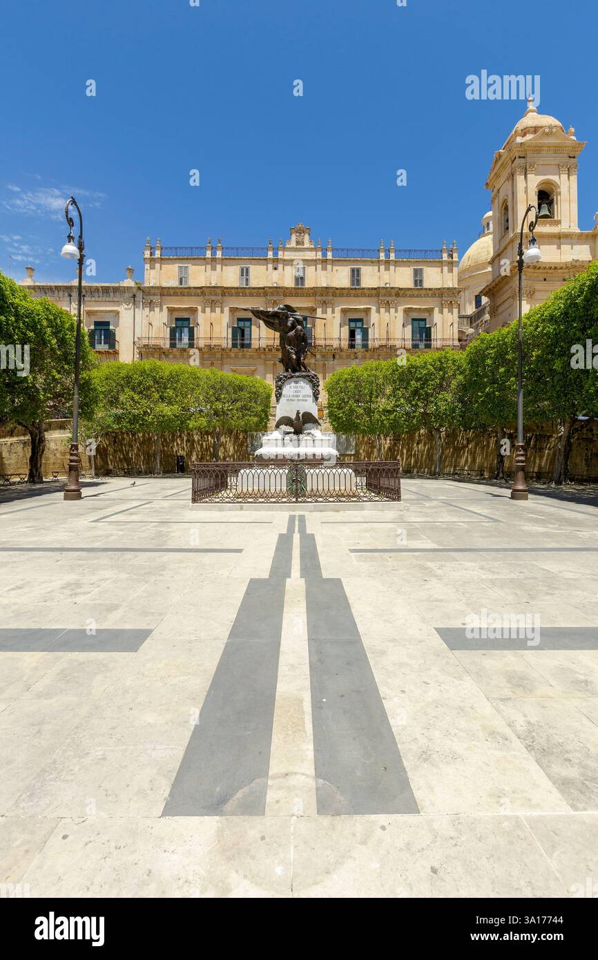 Italia, Sicilia, noto, città barocca dichiarata Patrimonio dell'Umanità dall'UNESCO, memoriale della prima guerra mondiale, facciata di Palazzo Landolina e cattedrale di San Nicolo (San Nicola) sullo sfondo Foto Stock