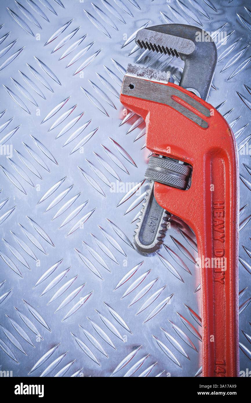 Chiave stringitubo regolabile in metallo su lamiera metallica scanalata con vista verticale Foto Stock