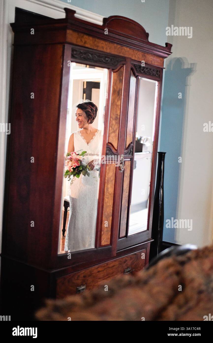 La sposa e lo sposo condividono un bacio romantico mentre si siede su un vintage Foto Stock