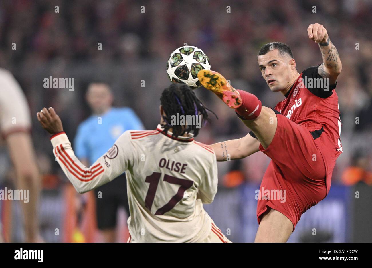Duello, azione Michael Olise FC Bayern Monaco FCB (17) contro Granit Xhaka Bayer 04 Leverkusen (34) UEFA Champions League Allianz Arena, Monaco, Baviera, Ger Foto Stock