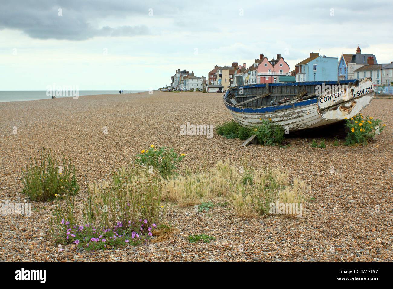 Spiaggia di Aldeburgh con barca da pesca e ville fronte mare color pastello, Aldeburgh, Suffolk, Regno Unito Foto Stock