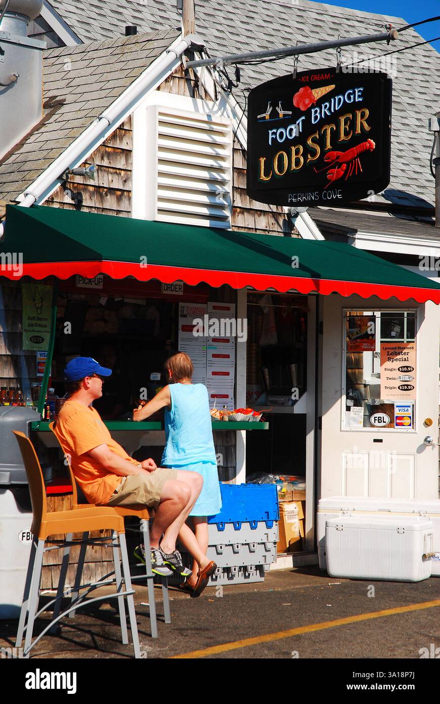 Un uomo adulto aspetta sua moglie fuori da una baracca di aragosta sulla costa del Maine Foto Stock