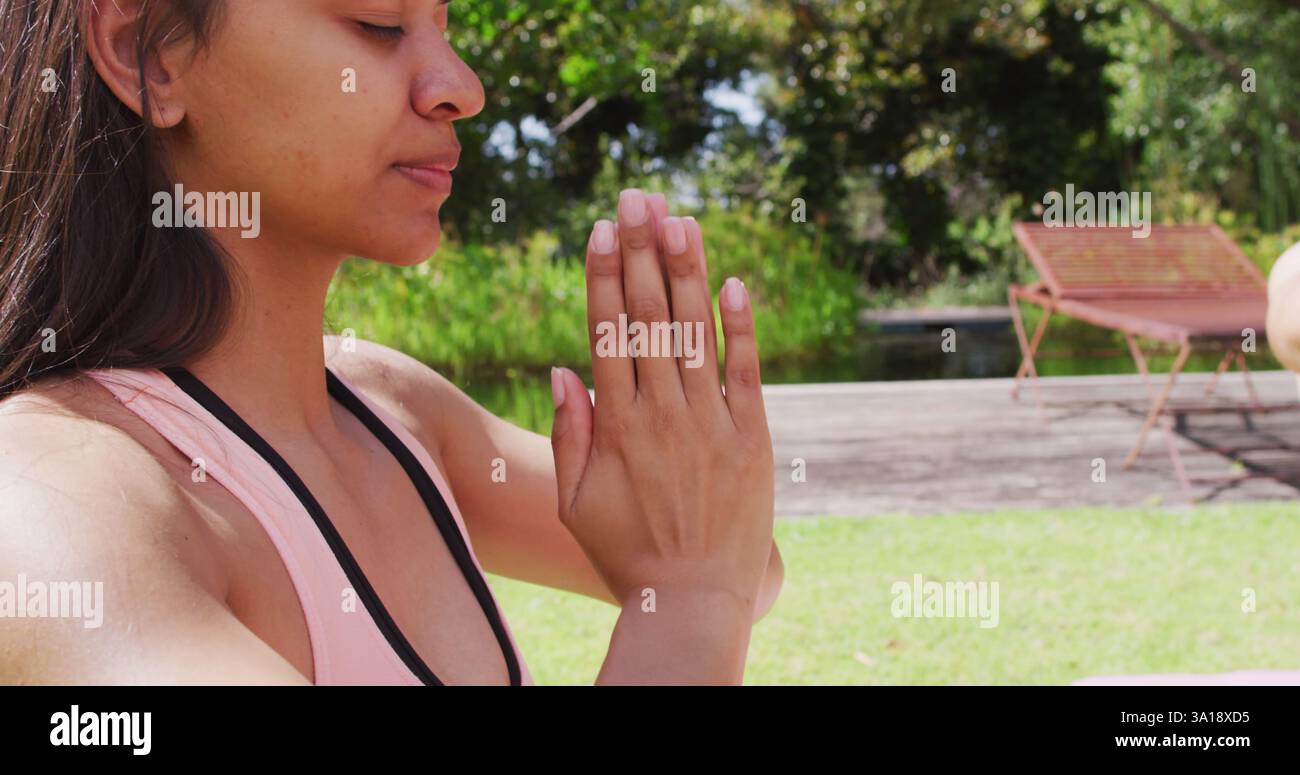 Gruppi diversi che praticano yoga posano con gli occhi chiusi nel parco soleggiato Foto Stock
