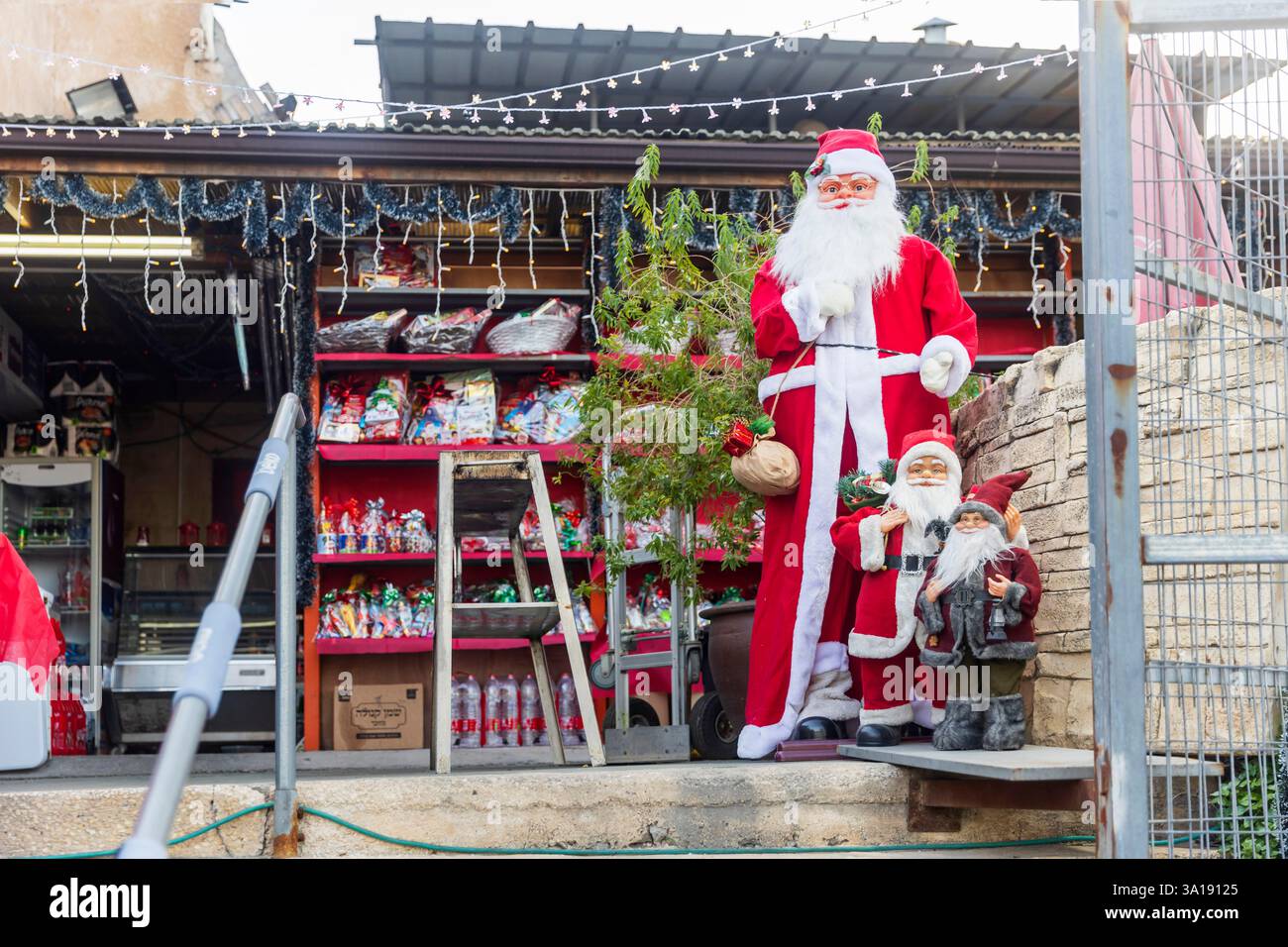 Haifa, Israele - 7 marzo 2025, vendita di caramelle, dolci e bevande per Natale. Due grandi figure di Babbo Natale sono collocate all'ingresso dello stor Foto Stock
