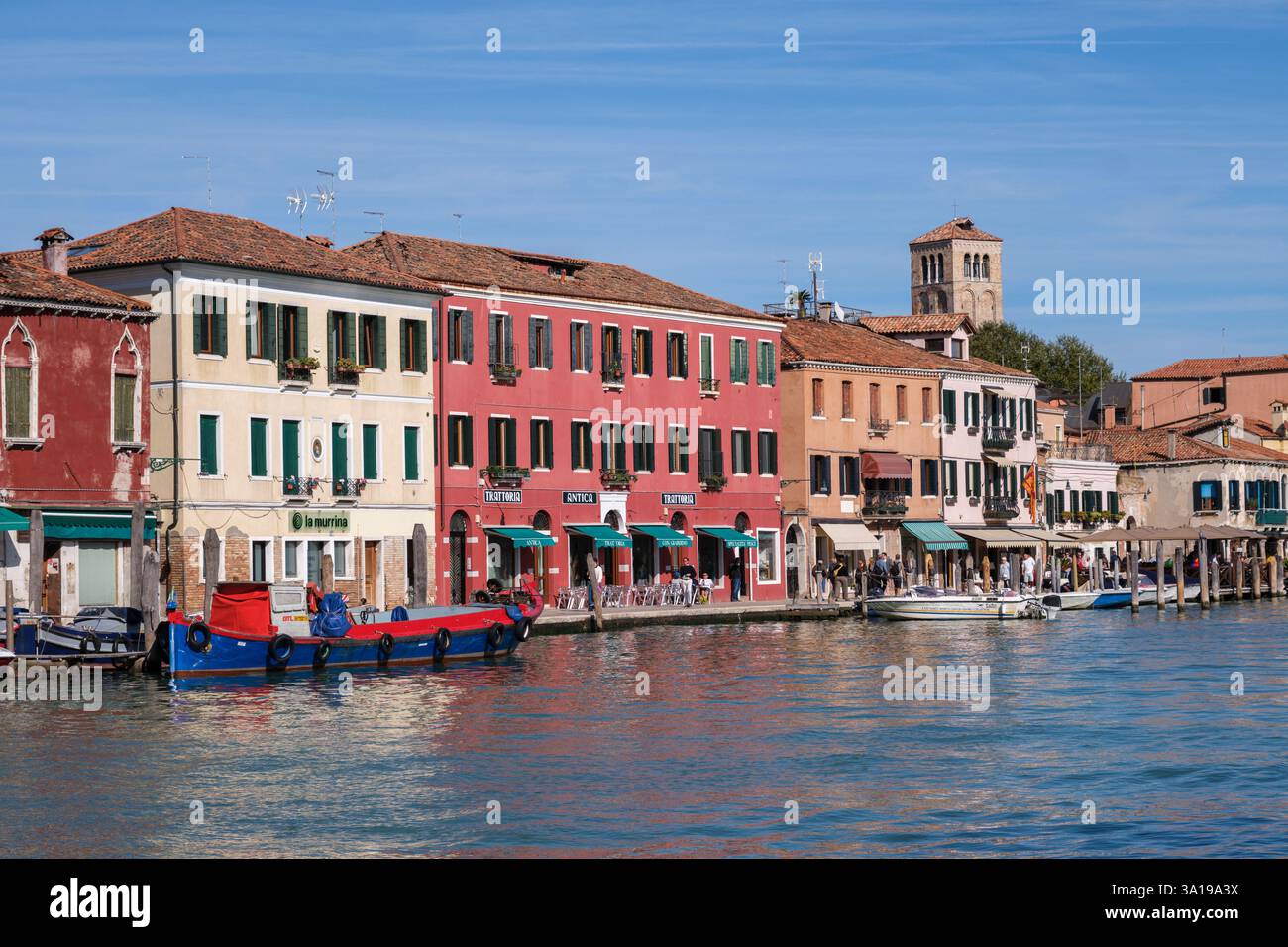 Venezia, Italia - 12 ottobre 2024: Una fila di colorati edifici sul lungomare a Murano Foto Stock