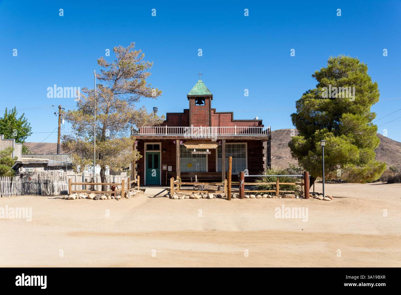 Pioneertown, USA - 27 settembre 2024: Edifici di Pioneertown annidati nell'alto deserto tra alberi di Giosuè Foto Stock