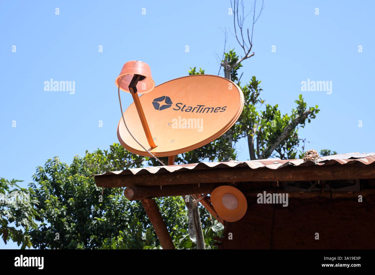 UGANDA, isola di Buvuma nel Lago Victoria, capanna in argilla con antenna a piatto per la ricezione dell'abbonamento alla pay TV satellitare della società cinese StarTimes, è collegata al programma del villaggio 10000 dell'agenzia cinese di sviluppo ChinaAid per portare la TV satellitare nelle aree rurali per diffondere serie TV, eventi sportivi e messaggi vincenti cinesi Foto Stock