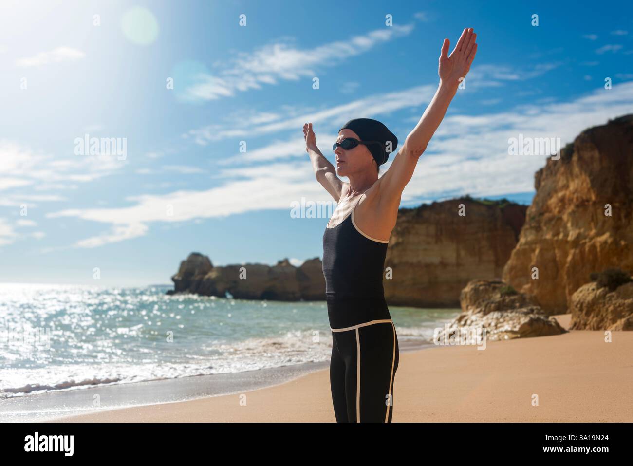 nuotatrice sportiva in spiaggia con le braccia sopra la testa Foto Stock