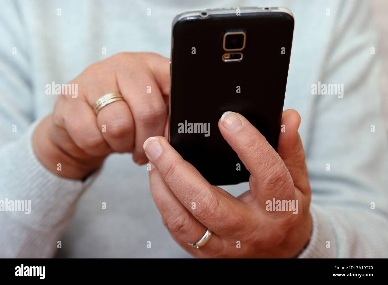 Donna in possesso di un telefono cellulare Foto Stock