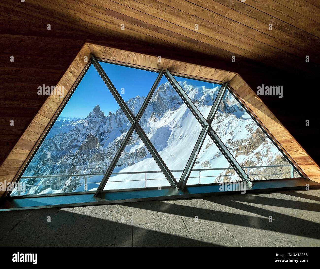 Ampie finestre panoramiche che mostrano le cime innevate del massiccio del Monte bianco in inverno, viste dal moderno punto panoramico in legno Foto Stock