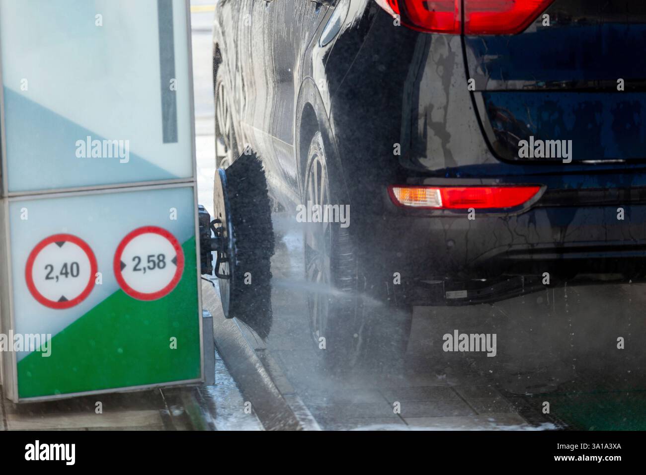 L'auto nera viene lavata in un autolavaggio automatico con spazzole e sapone Foto Stock