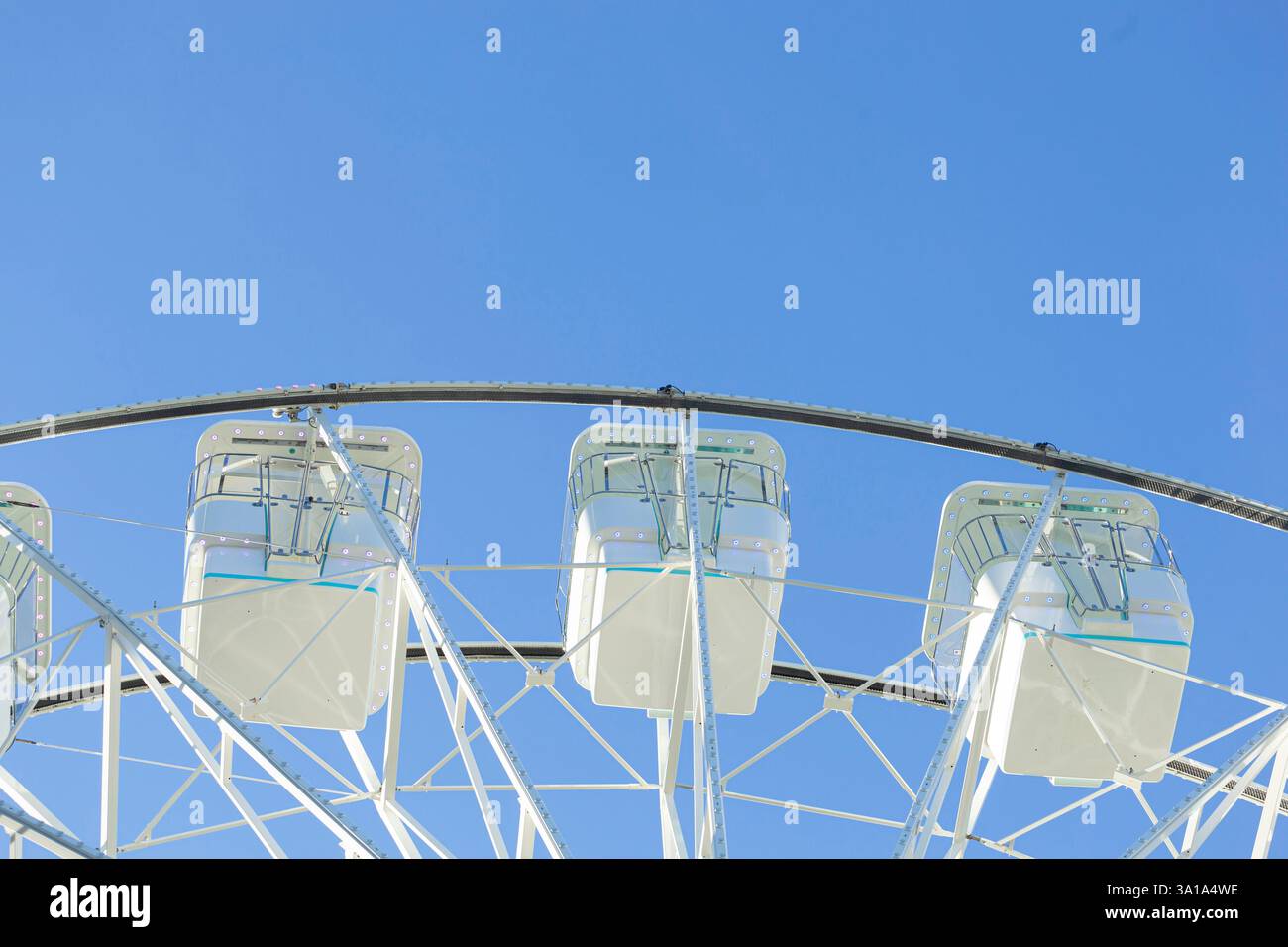 Ruota panoramica sullo sfondo blu del cielo. Attrazione presente nei parchi divertimenti. Foto Stock
