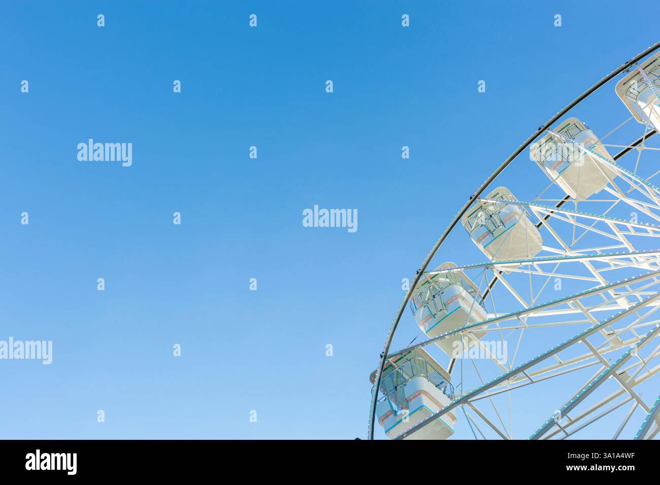 Ruota panoramica sullo sfondo blu del cielo. Attrazione presente nei parchi divertimenti. Foto Stock