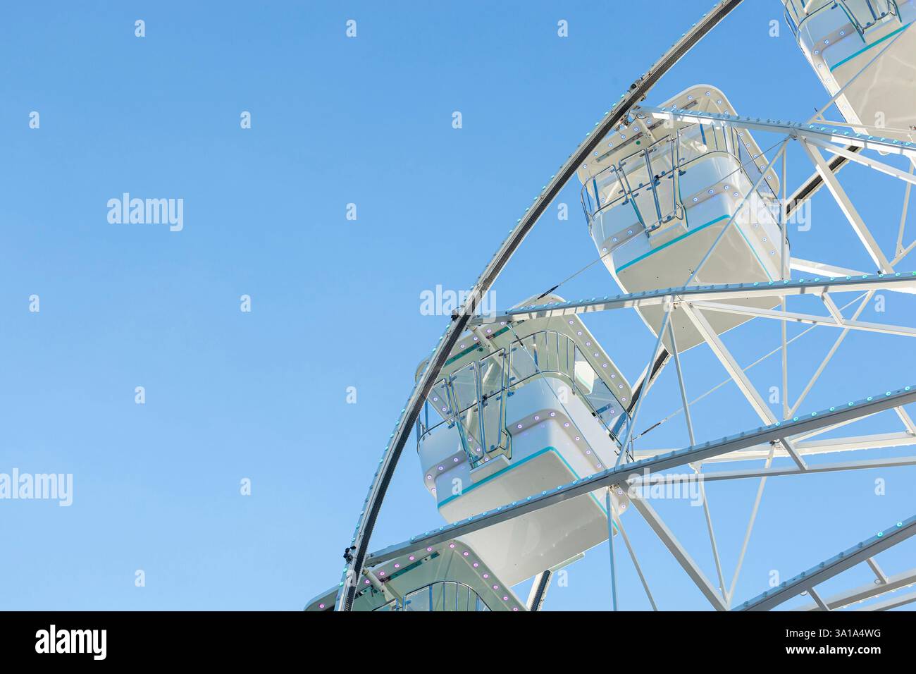 Ruota panoramica sullo sfondo blu del cielo. Attrazione presente nei parchi divertimenti. Foto Stock